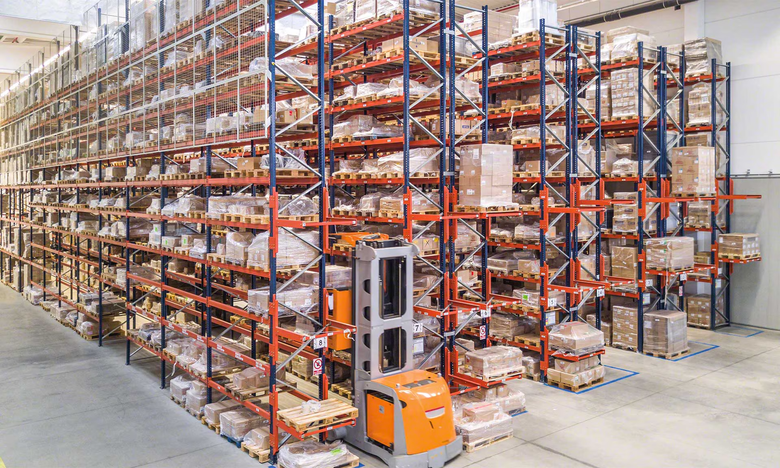 Automated stacker crane serving a tall high-bay pallet storage system