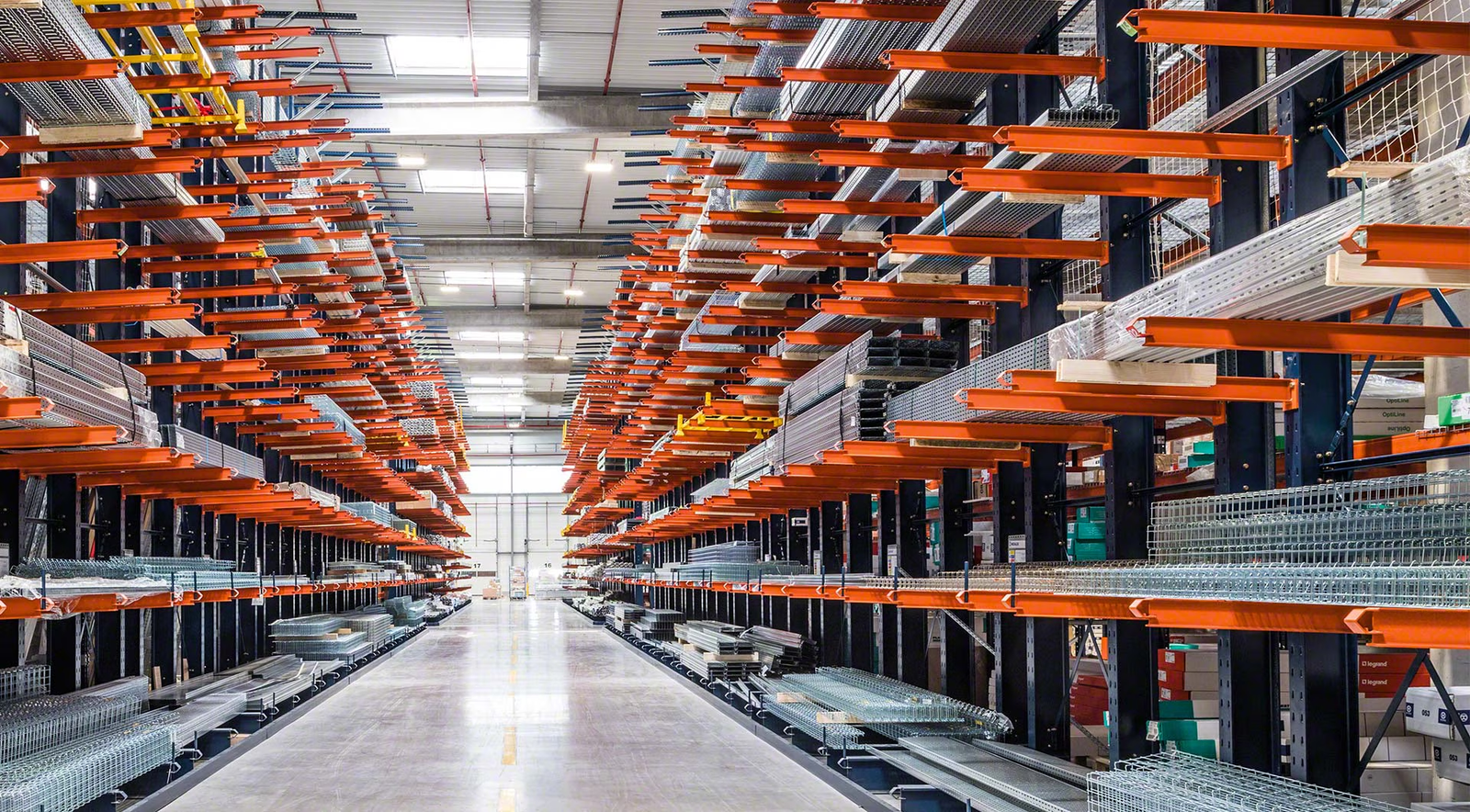Wide warehouse aisle between rows of orange and blue pallet racking