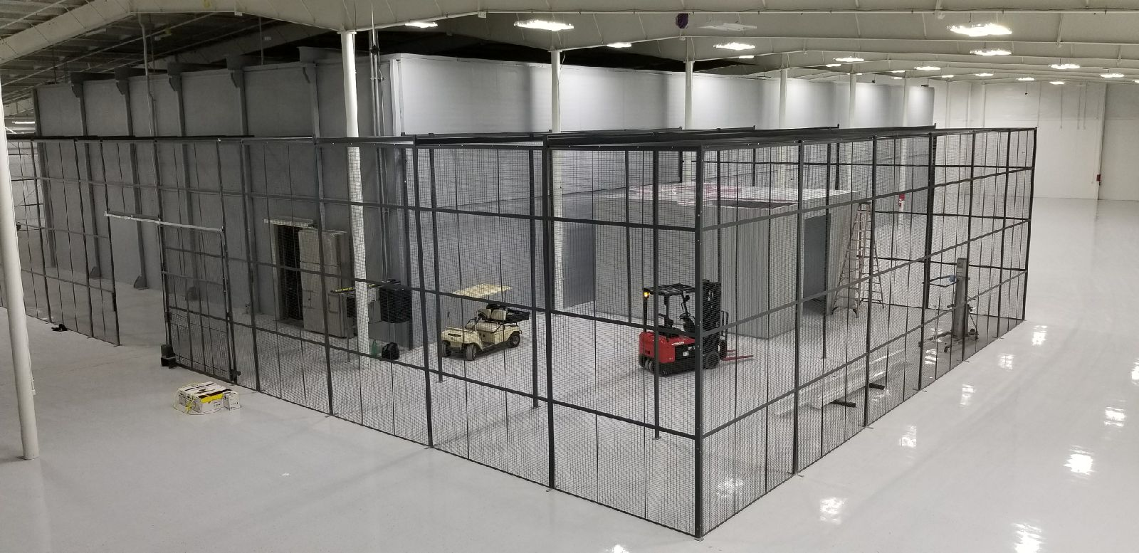 Secure caged warehouse storage zone for high-value electronic inventory