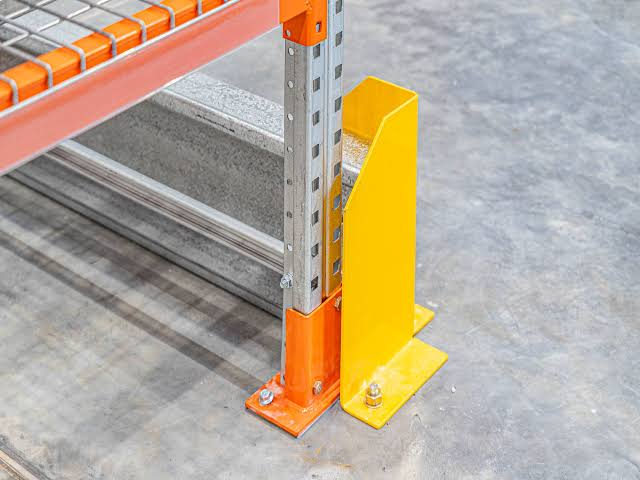 Floor-anchored pallet rack upright protector reducing forklift impact damage